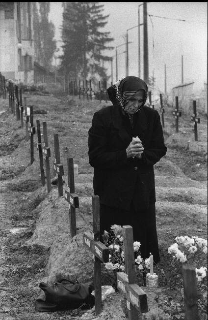 Sarajevo. 1993. Catholic Croat woman cries over the tomb of a victim of Serbian fire. Many Serbs and Croats remain in the city which boasted a cosmopolitan population and a sophisticated cultural life before the war.