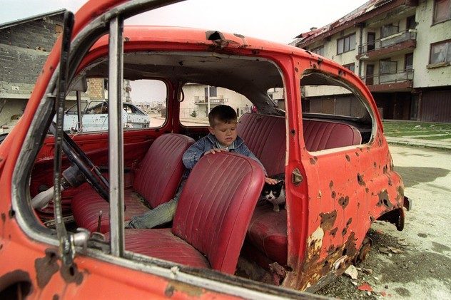 Bosnian boy plays in the destroyed car in Dobrinja suburb of Sarajevo, Bosnia And Herzegovina, 11 April 1996. EPA/ANJA NIEDRINGHAUS