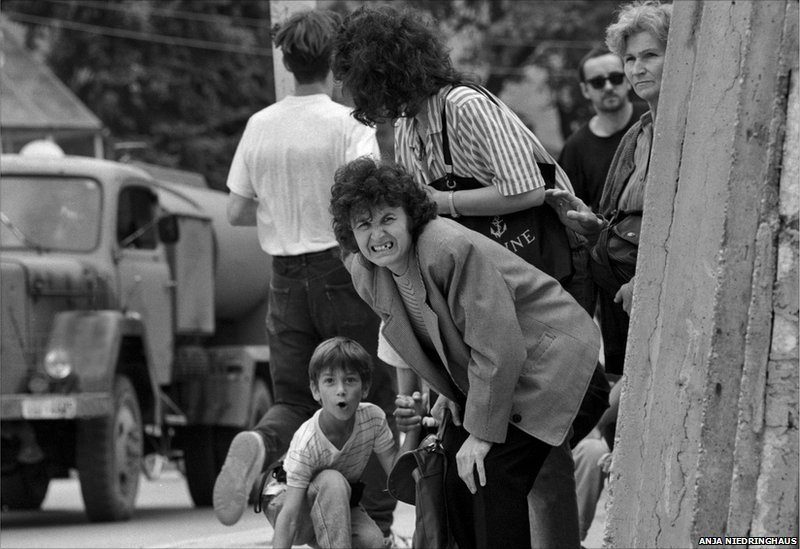 A woman and her son take cover behind a concrete wall erected to protect them from incoming sniper fire. Sarajevo, Bosnia And Herzegovina, 12 June 1995. EPA/ANJA NIEDRINGHAUS