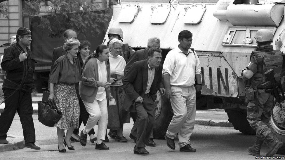 Pedestrians take cover behind the UN APC, passing the dangerous zone of sniping in Sarajevo, Bosnia And Herzegovina. EPA/ANJA NIEDRINGHAUS