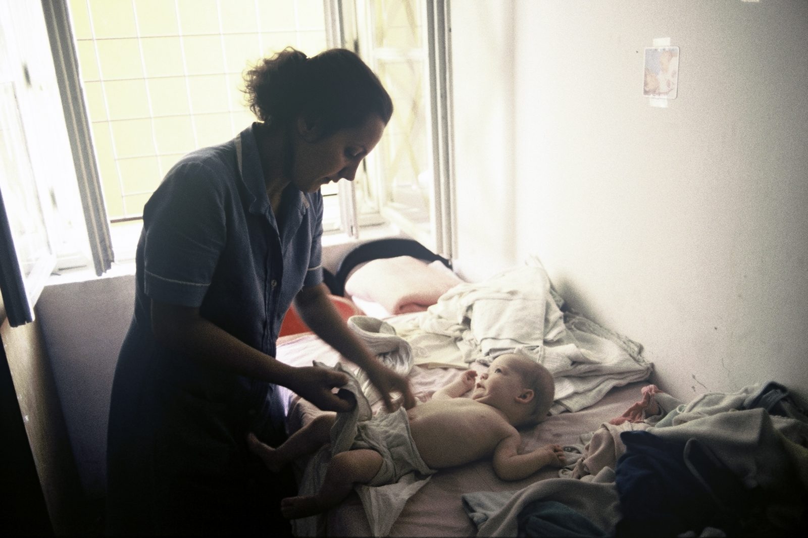 In the toddler group of the 'Ljubica Ivezic' orphanage, a caregiver puts diapers on one of the toddlers. Bosnia and Herzegovina, Sarajevo 01.08.1992