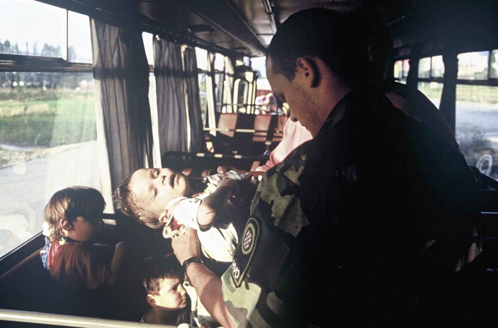 HVO soldier is holding Vedrana Glavas (2 years old), who was badly wounded by the Serb forces. Bosnia and Herzegovina, Sarajevo 01.08.1992