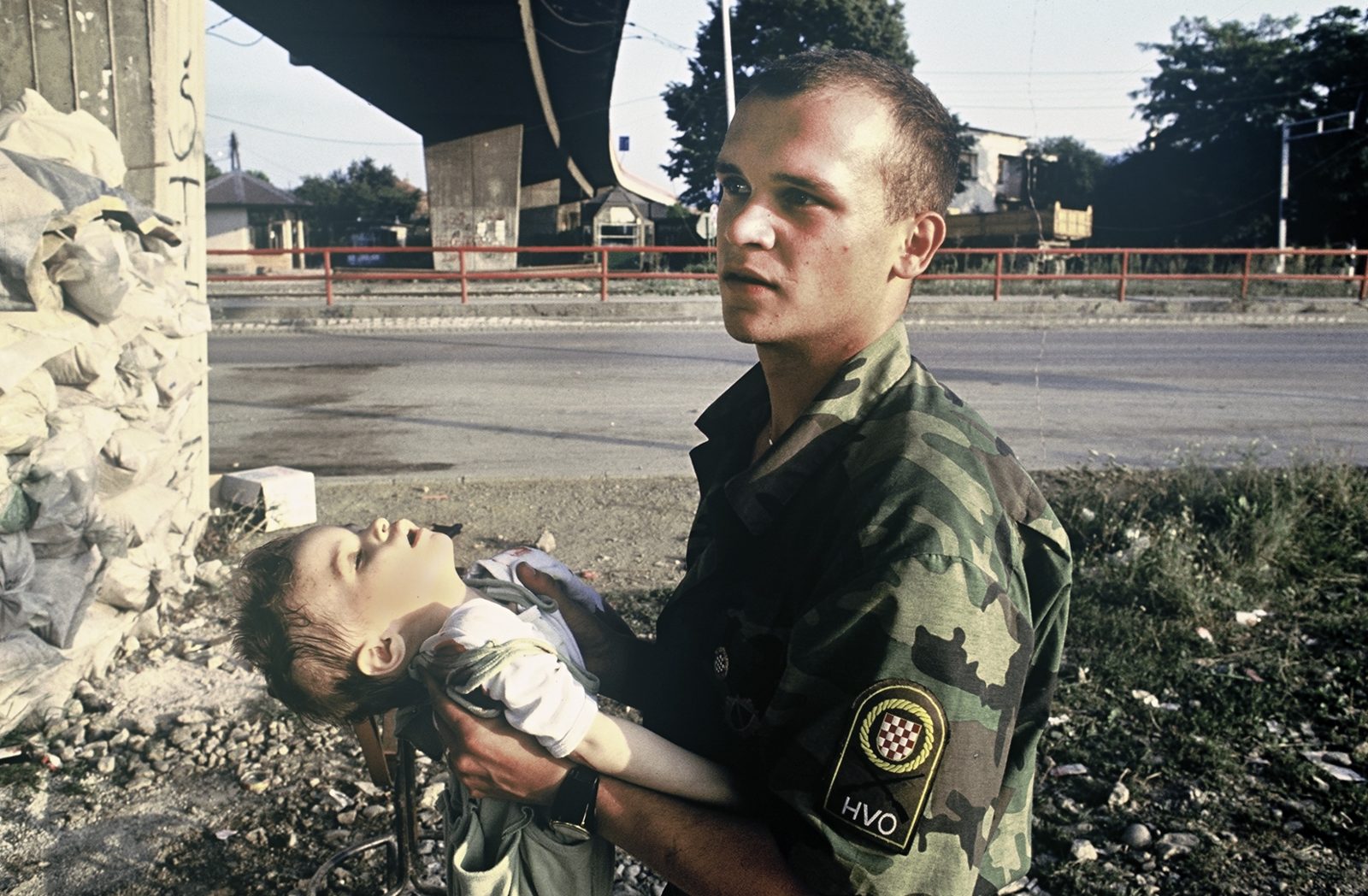 HVO soldier holds Vedrana Glavas (2 years old), who was badly wounded by the attack. A little later she passed away in his arms. Bosnia and Herzegovina, Sarajevo 01.08.1992
