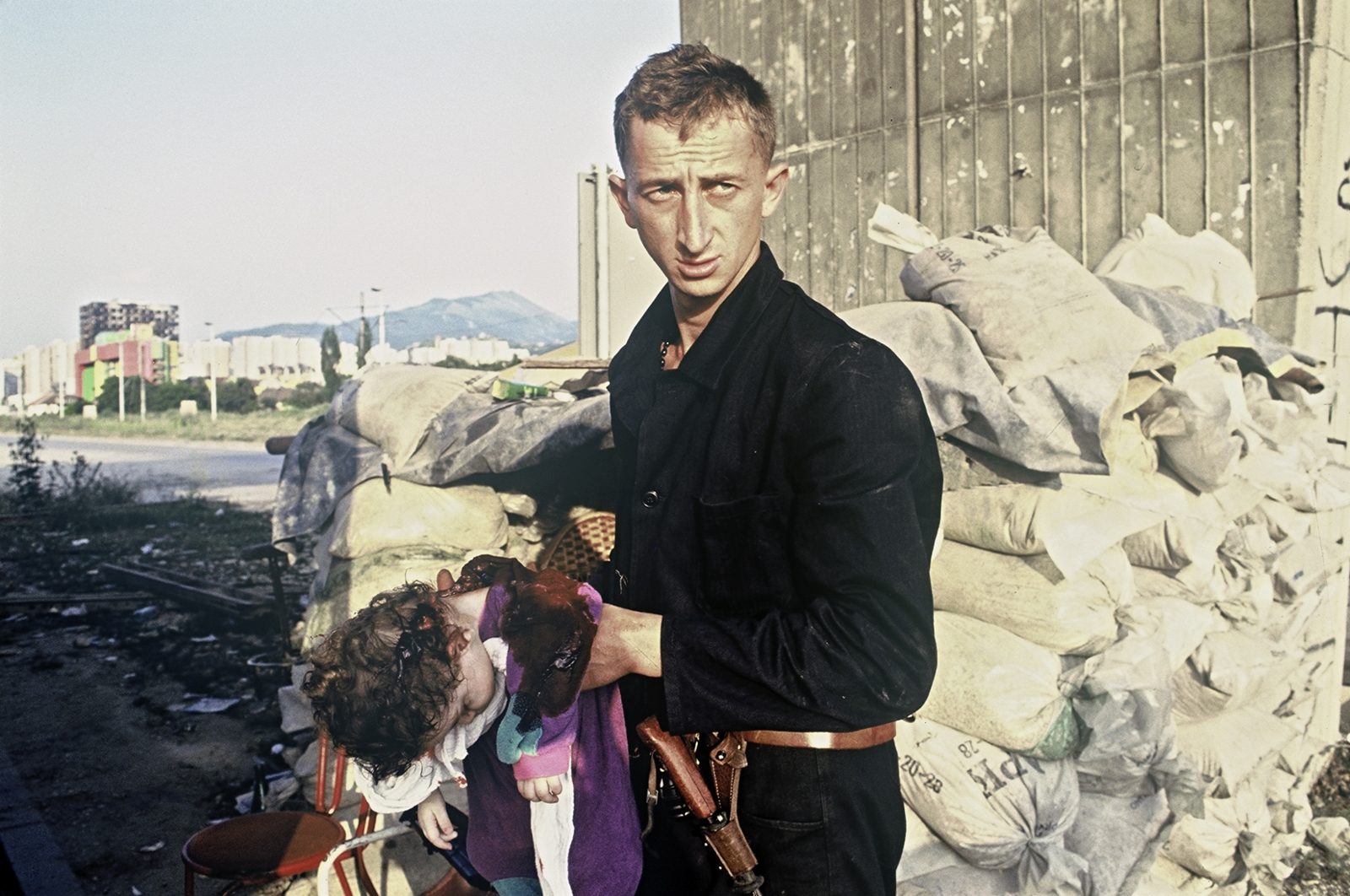 A Bosnian soldier is holding Roki Sulejmanovic (1-year-old) killed by the Serb forces. Bosnia and Herzegovina, Sarajevo 01.08.1992