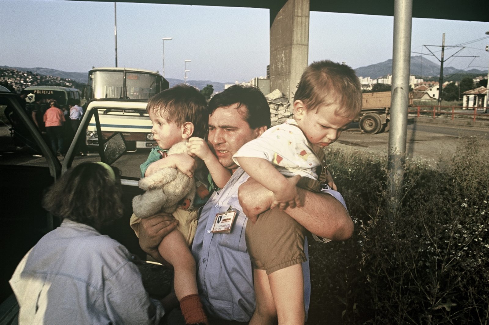 After the sniper attack on the getaway bus, a Bosnian policeman carries the children into the vans provided. Bosnia and Herzegovina, Sarajevo 01.08.1992