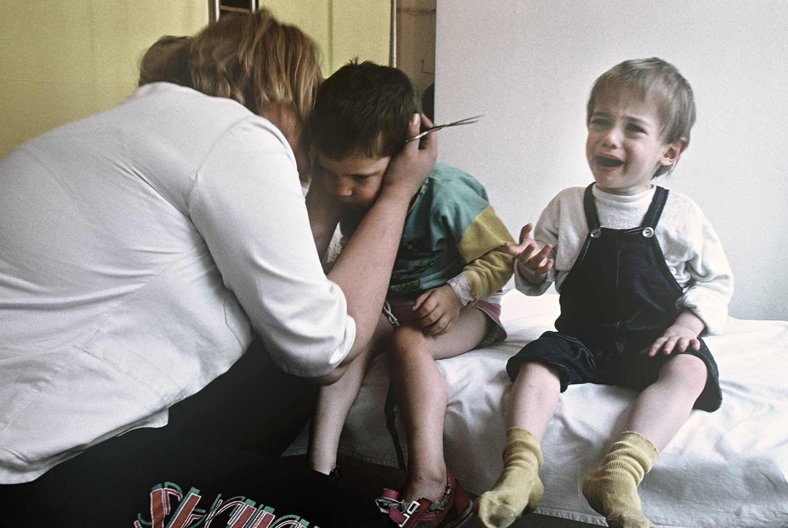 Caregiver Illjana bids farewell to the children, whose surrender was forced by a Serb authority. The children were marked with name ribbons on their wrists, Bosnia and Herzegovina, Sarajevo 02.08.1992