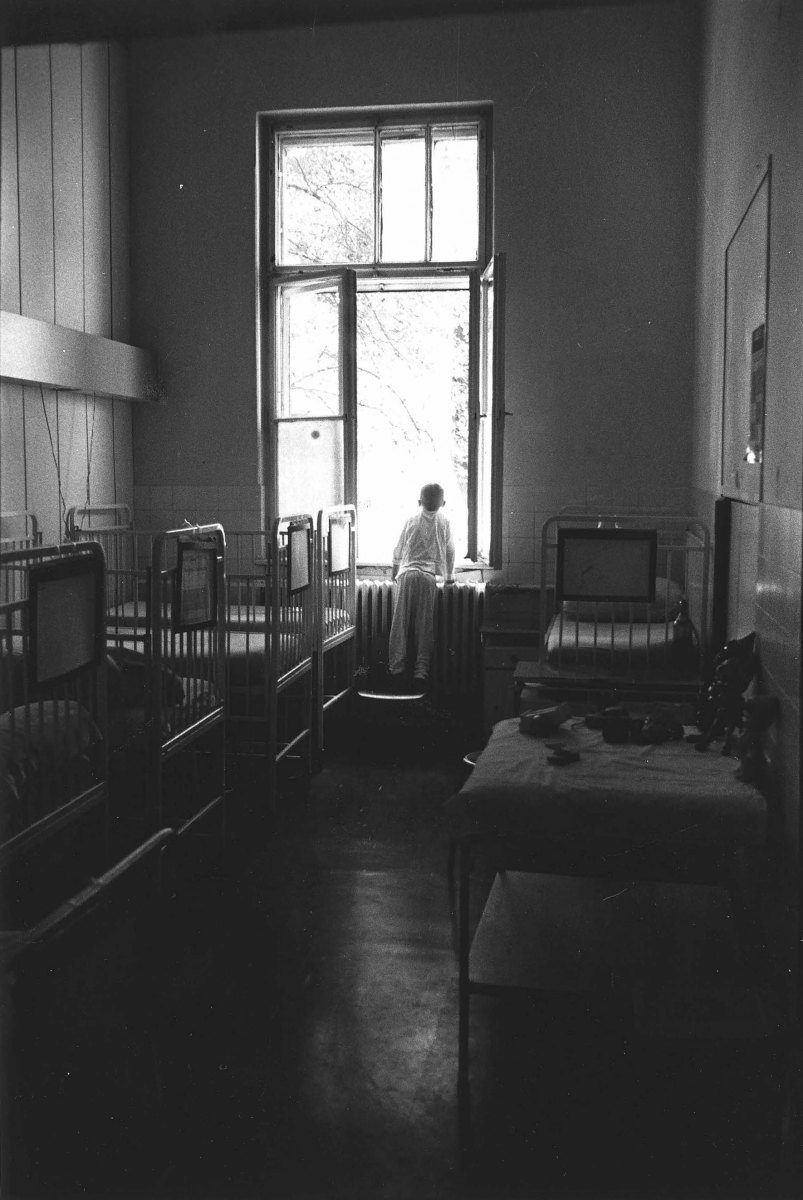 A orphan child look out the window in the Sarajevo Hospital , august 1993.