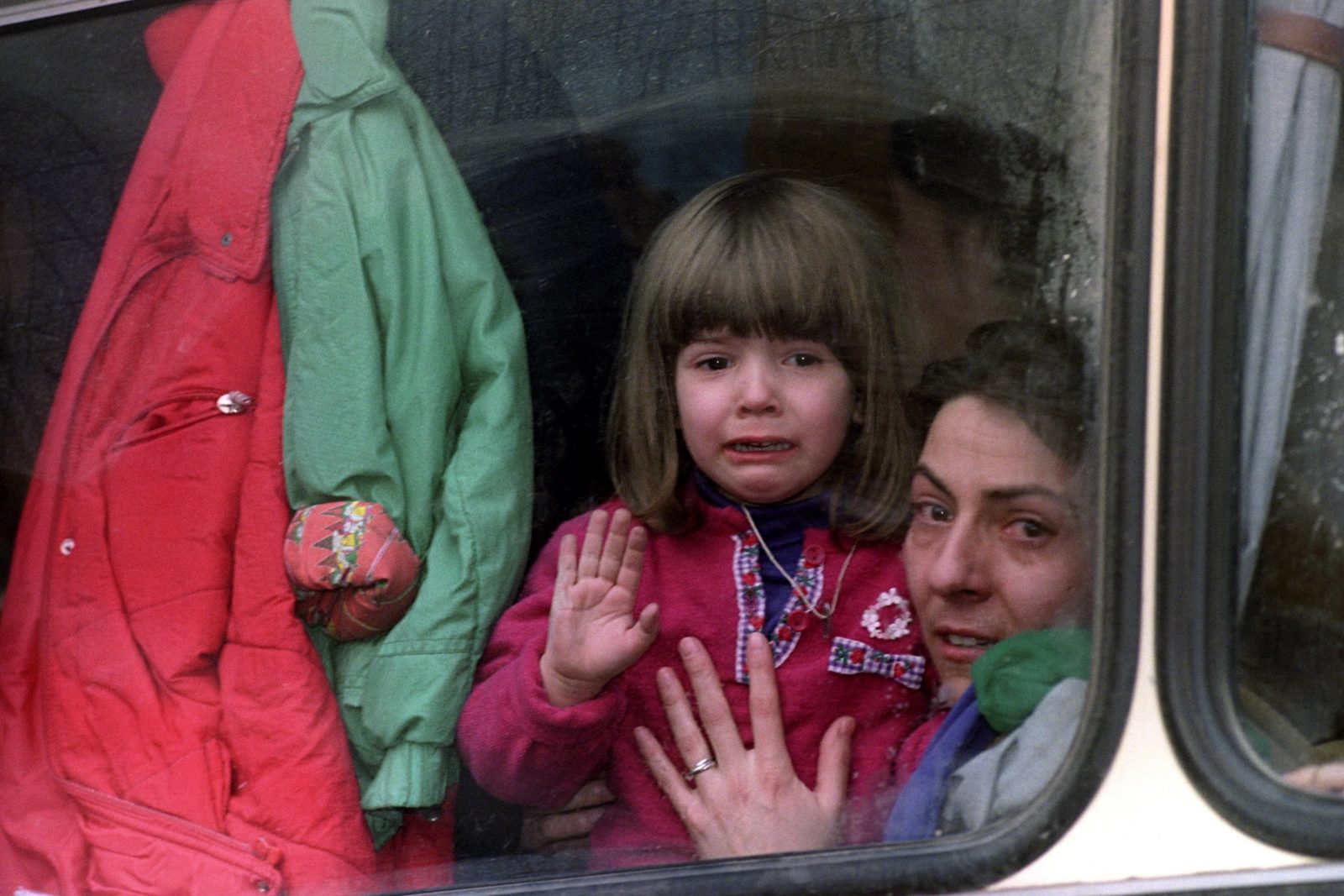 A mother and her child kiss goodbye to relatives as they leave Sarajevo on 26 November 1992 to visit other family members in another part of Bosnia. EPA | DIMITRI MESSINIS