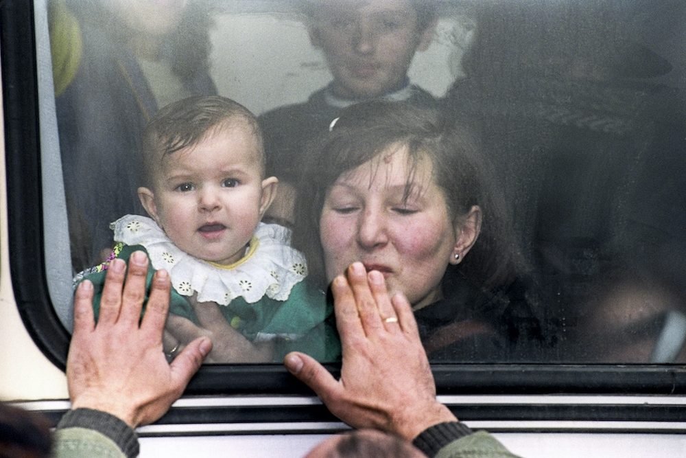 A mother and her child kiss goodbye to relatives as they leave Sarajevo on 26 November 1992 to visit other family members in another part of Bosnia. EPA | DIMITRI MESSINIS