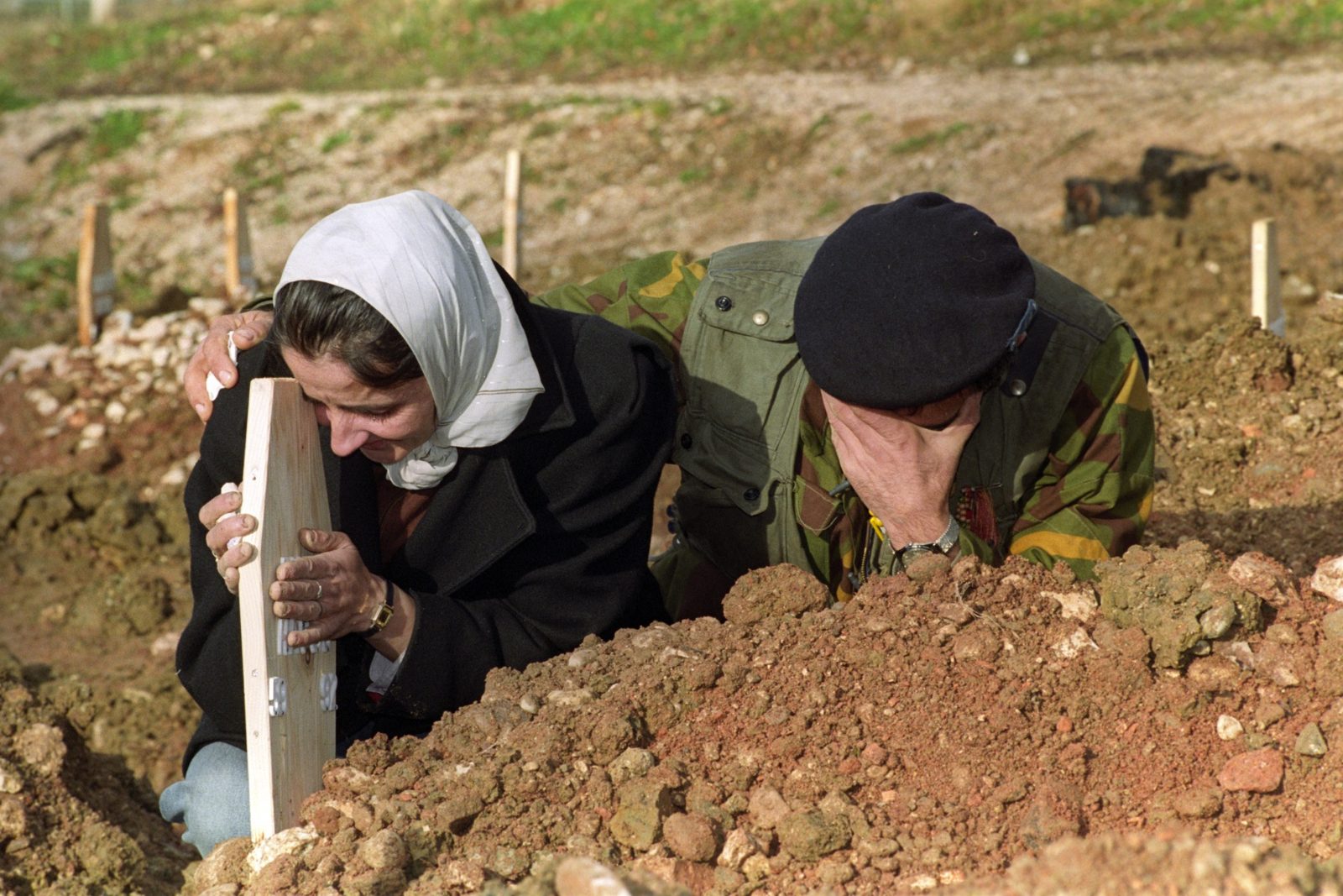 A Bosnian woman and her son, Bosnian fighter, mourn at the grave of her husband in Sarajevo, 6 December 1992. EPA | DIMITRI MESSINIS