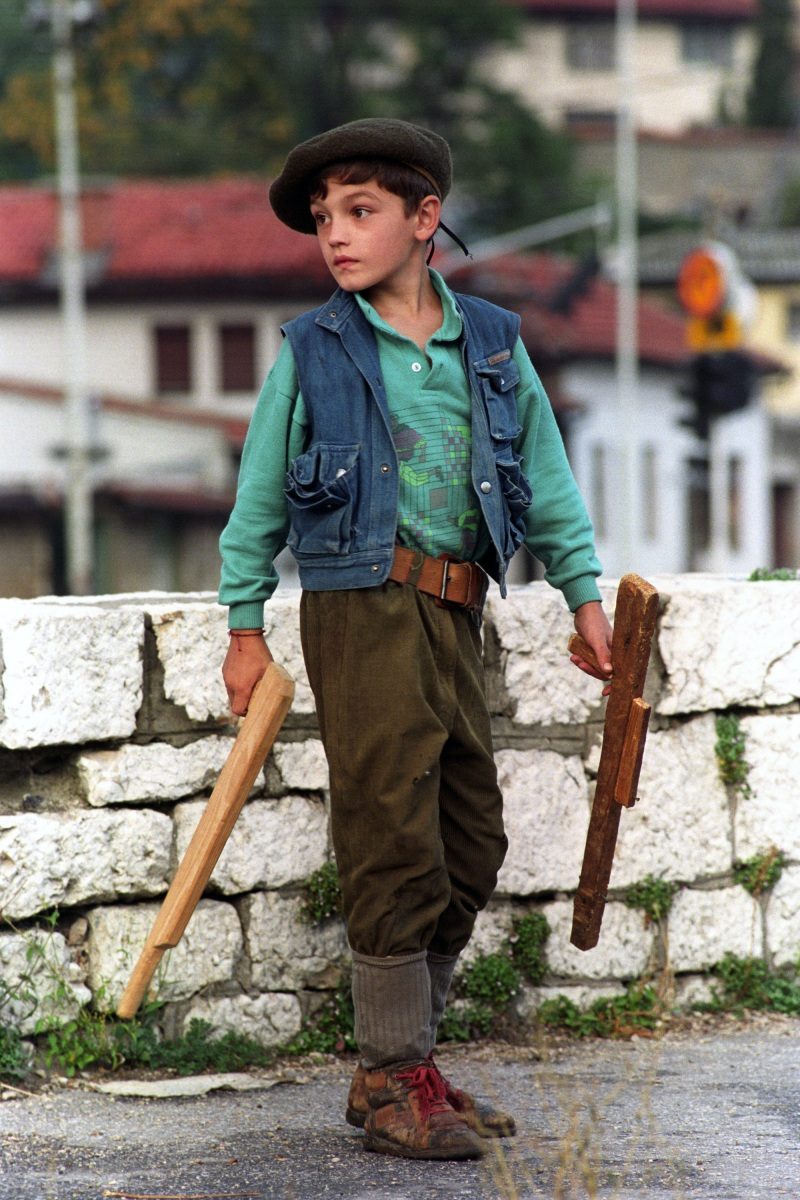 A young boy holds weapons carved from wood in Sarajevo, Bosnia and Hercegovina, 26 September 1993.