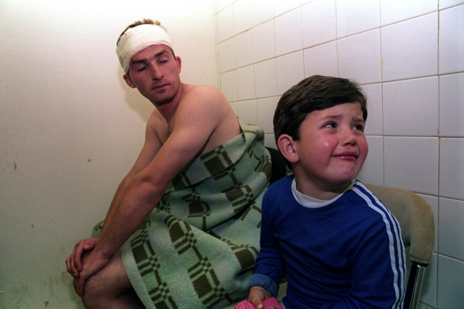 Wounded man and little boy wait for treatment in the hospital after the mortar attack by Serb Forces in Sarajevo, Bosnia And Herzegovina, 1 June 1993. Eleven people, four of them children, were killed in the attack.