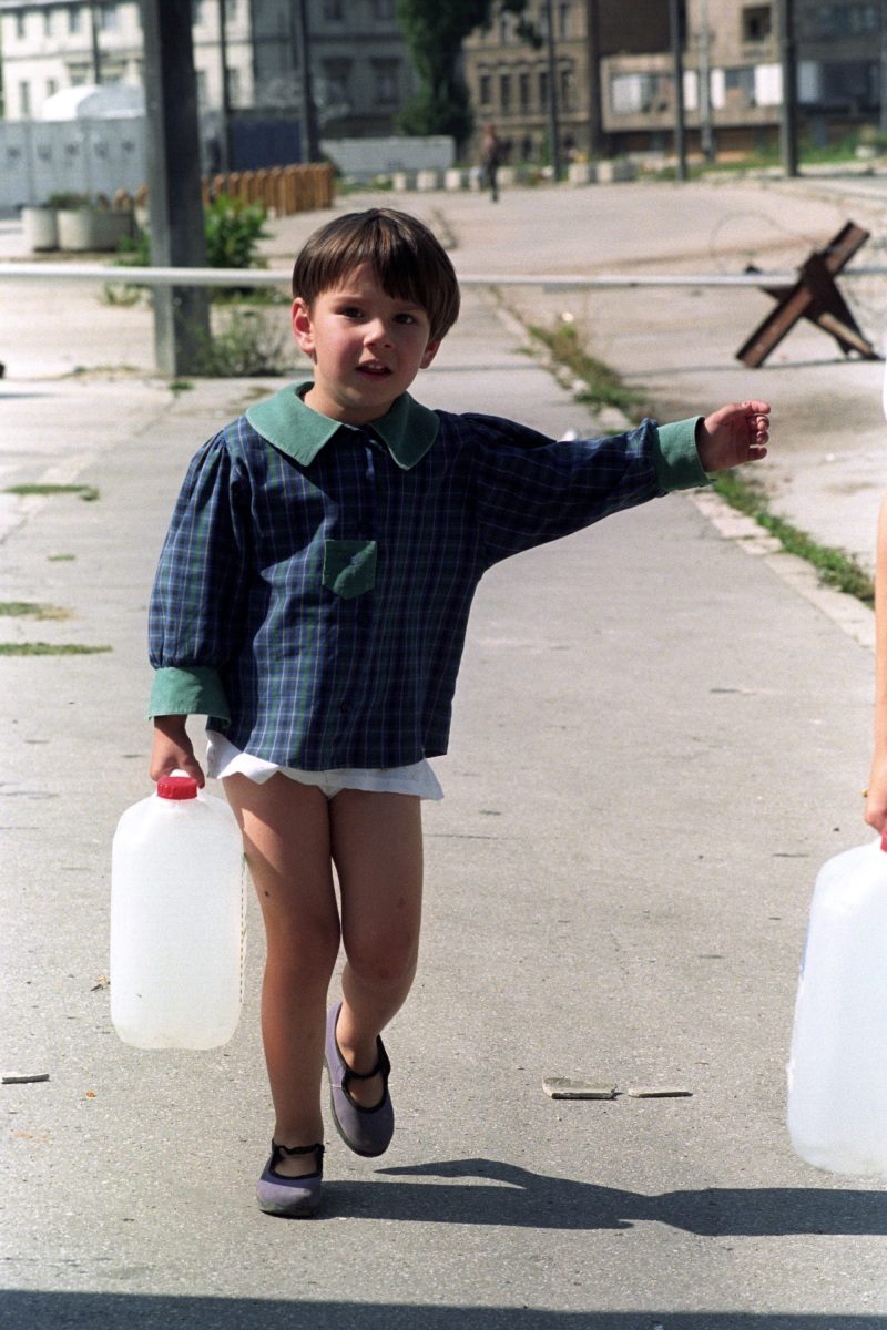 A little girl helps her parents to collect water from a distribution point in Sarajevo, Bosnia and Hercegovina, 18 September 1993.