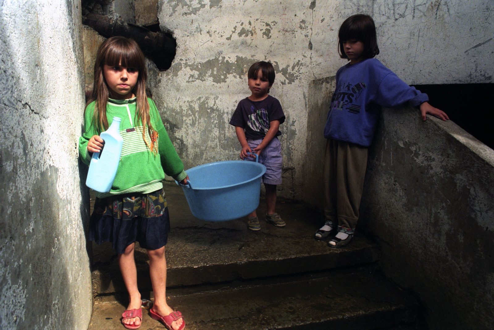 Brother and sisters help their mother with clothes washing chores in Sarajevo, Bosnia and Hercegovina, 19 September 1993.
