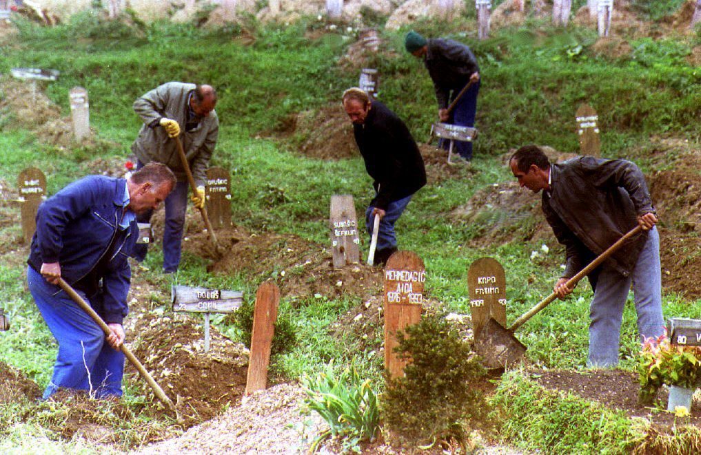 Gravediggers use shovels to remove grass from Moslem tombs at the cemetery at the Kosevo soccer stadium. Lord David Owen increased pressure 31 August 1993 to sign a peace accord, warning there is a "real danger" the serbs could cut Bosnia-Herzegovina in two. (Photo by GABRIEL BOUYS / AFP)