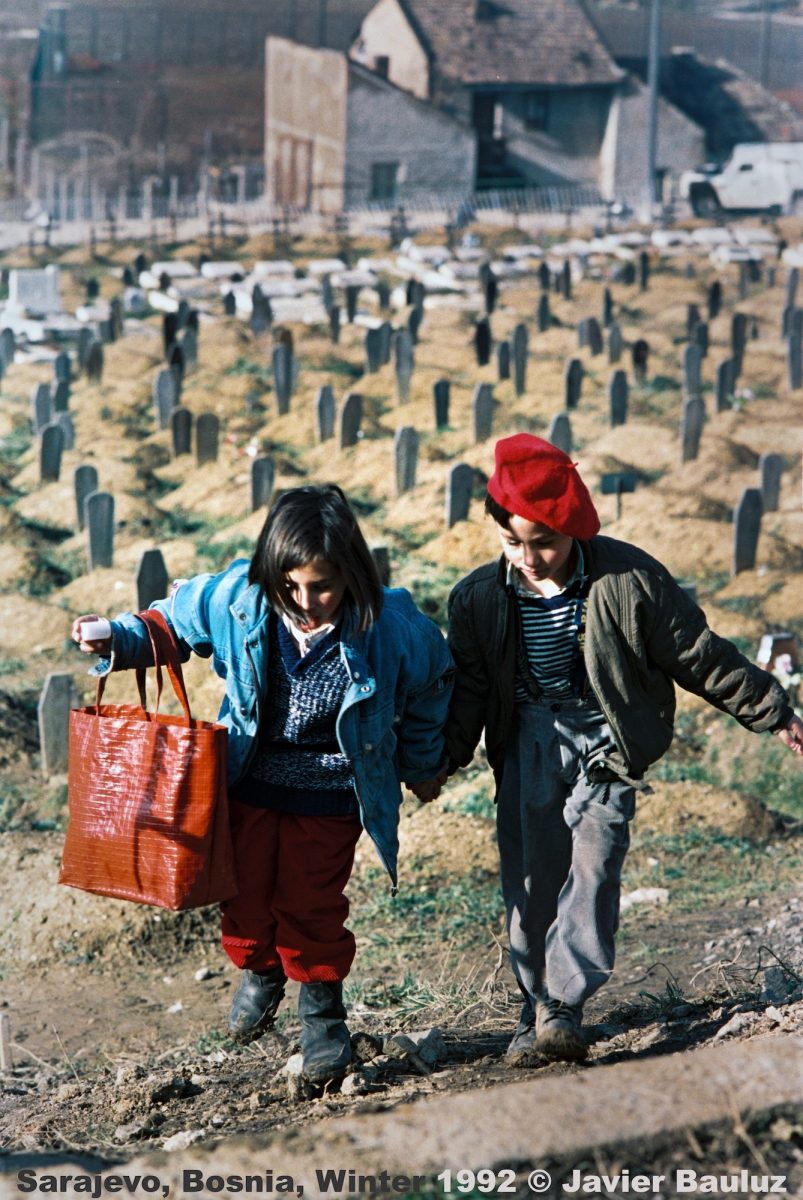 Amela & Amel, cousins ​​ages 10 and 8, run to avoid Serb snipers as they cross the park-turned cemetery to beg for leftovers from Kosevo Hospital, Sarajevo Bosnia and Herzegovina, Winter 1992.