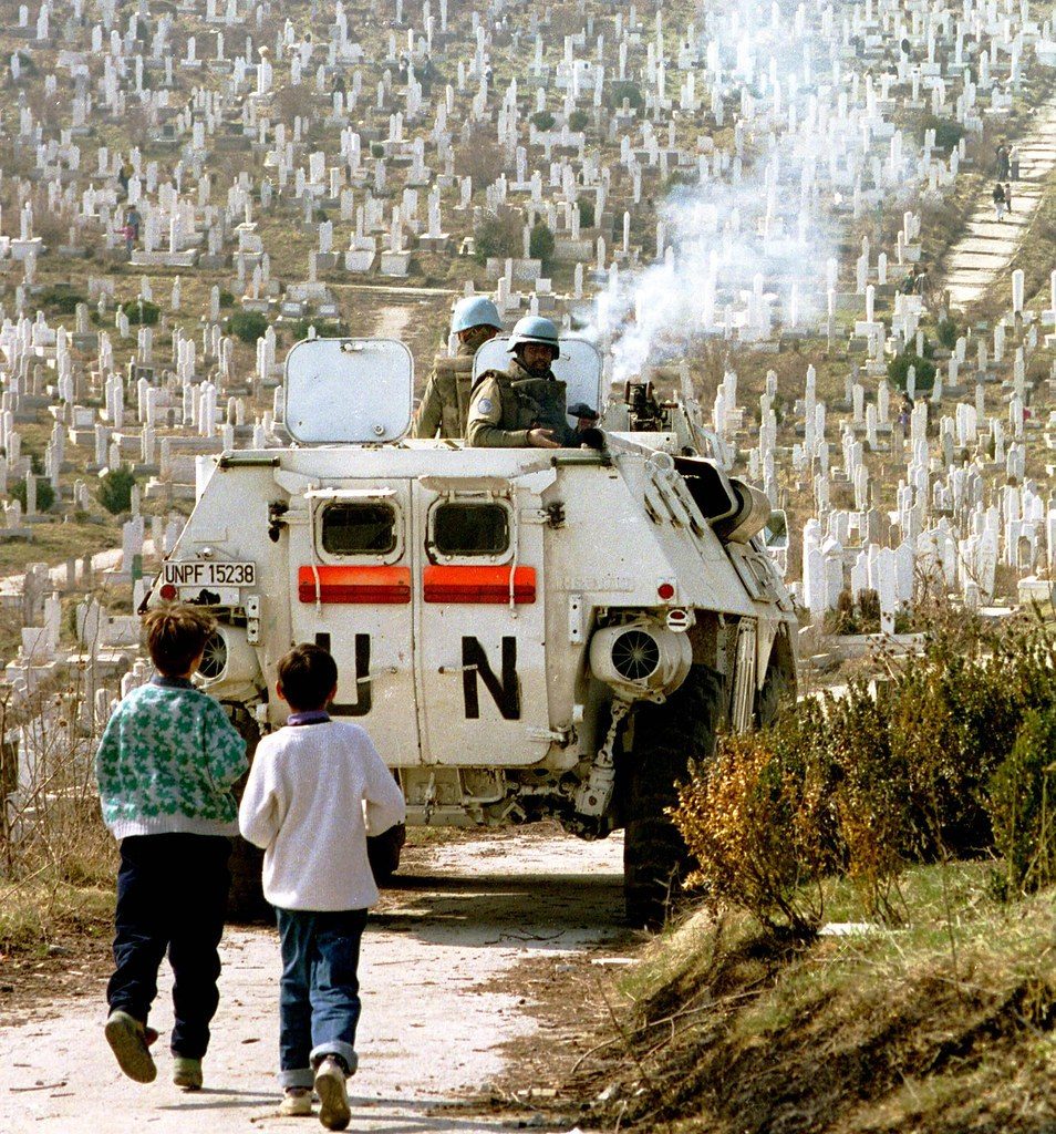 SARAJEV0, 09 MAY 1993 ------- Bosnian children follow a United Nations Protection Force (UNPROFOR) APC through a Sarajevo cemetary. © Photo Credit: Mark H. Milstein/ Northfoto