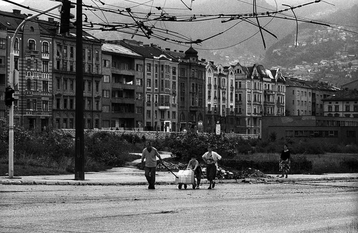 A family while carrying water supply in the centre of Sarajevo. Sarajevo, Bosnia and Herzegovina, August 1993