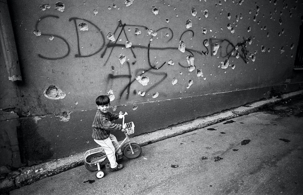 A kid on his tricycle in the centre of Sarajevo. Sarajevo, Bosnia and Herzegovina, August 1993