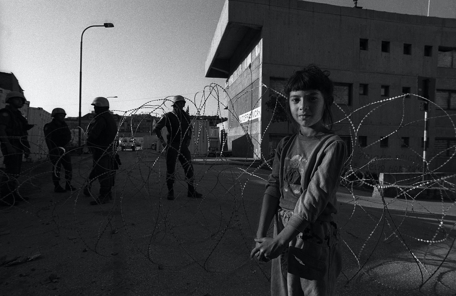 A young girl while standing in front of the UN conpound in the centre of Sarajevo. Sarajevo, Bosnia and Herzegovina, August 1993