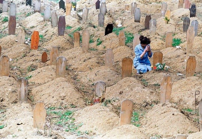 A Bosnian Muslim woman weeps over one of the many graves in a Sarajevo cemetery, April 18, 1993.