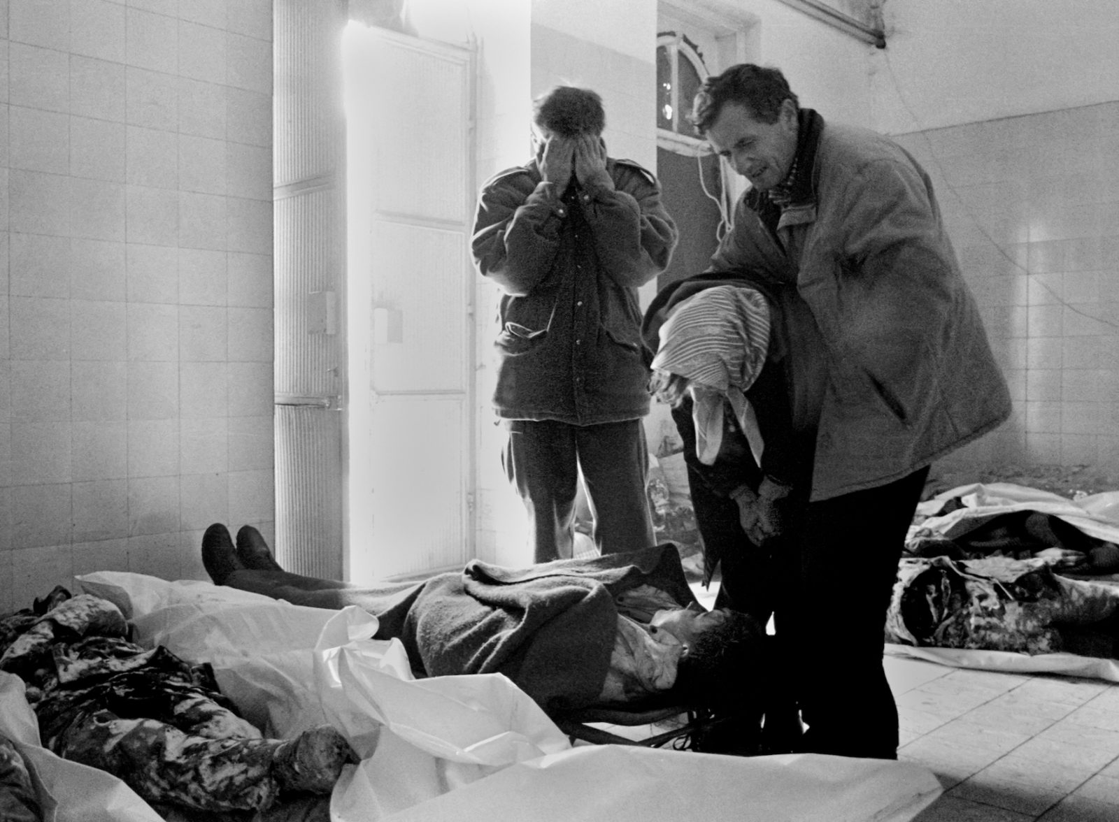 A family cries as they identify one of their own in the morgue at Sarajevo's Kosevo hospital on January 7, 1993.