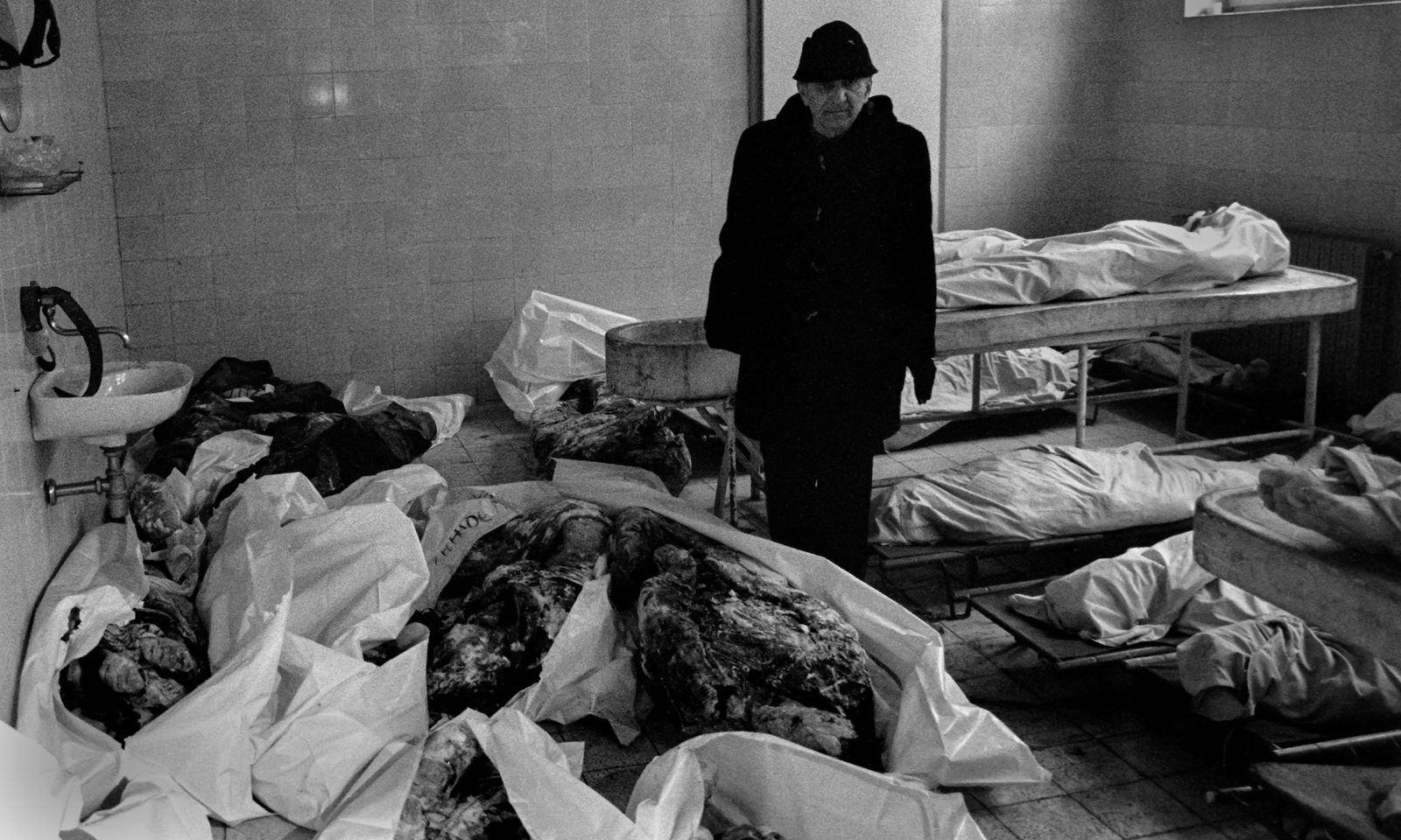 A man looks for a missing friend or relative among newly arrived corpses in the besieged Bosnian capital Sarajevo morgue on December 15, 1992.