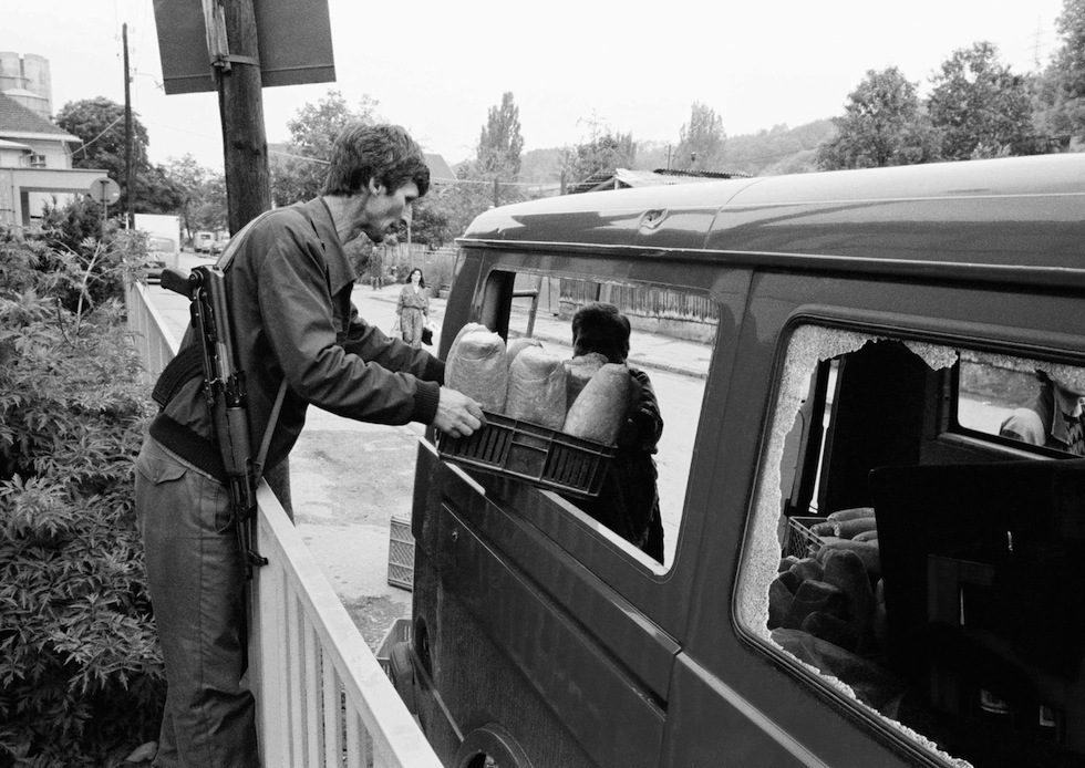 A Bosnian soldier loads a crate of bread from the Klas bakery in Sarajevo, June 19, 1992. Brave drivers must drive their trucks fast enough to avoid death in the regular hail of sniper bullets faced on daily deliveries. Into its third month of the siege, Sarajevo has very little to eat other than bread, and that could run out soon.