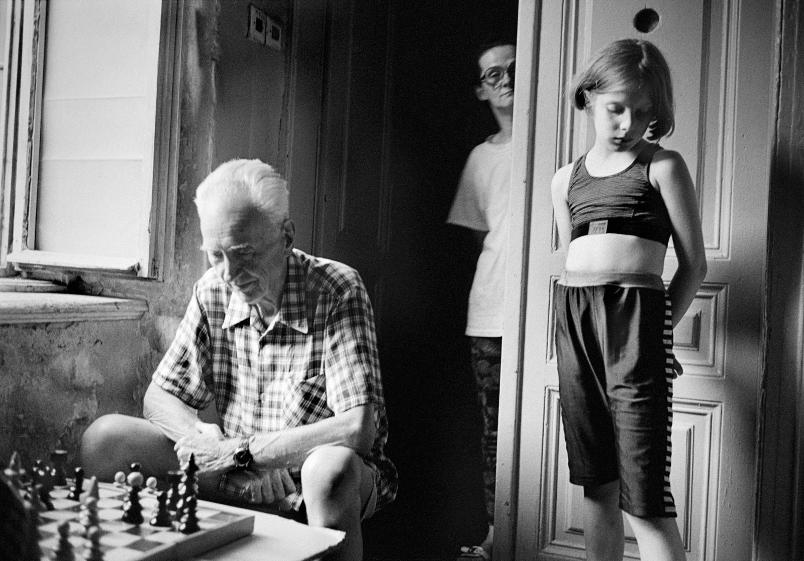 A family play chess in the hallway outside their apartment during the siege of Sarajevo.