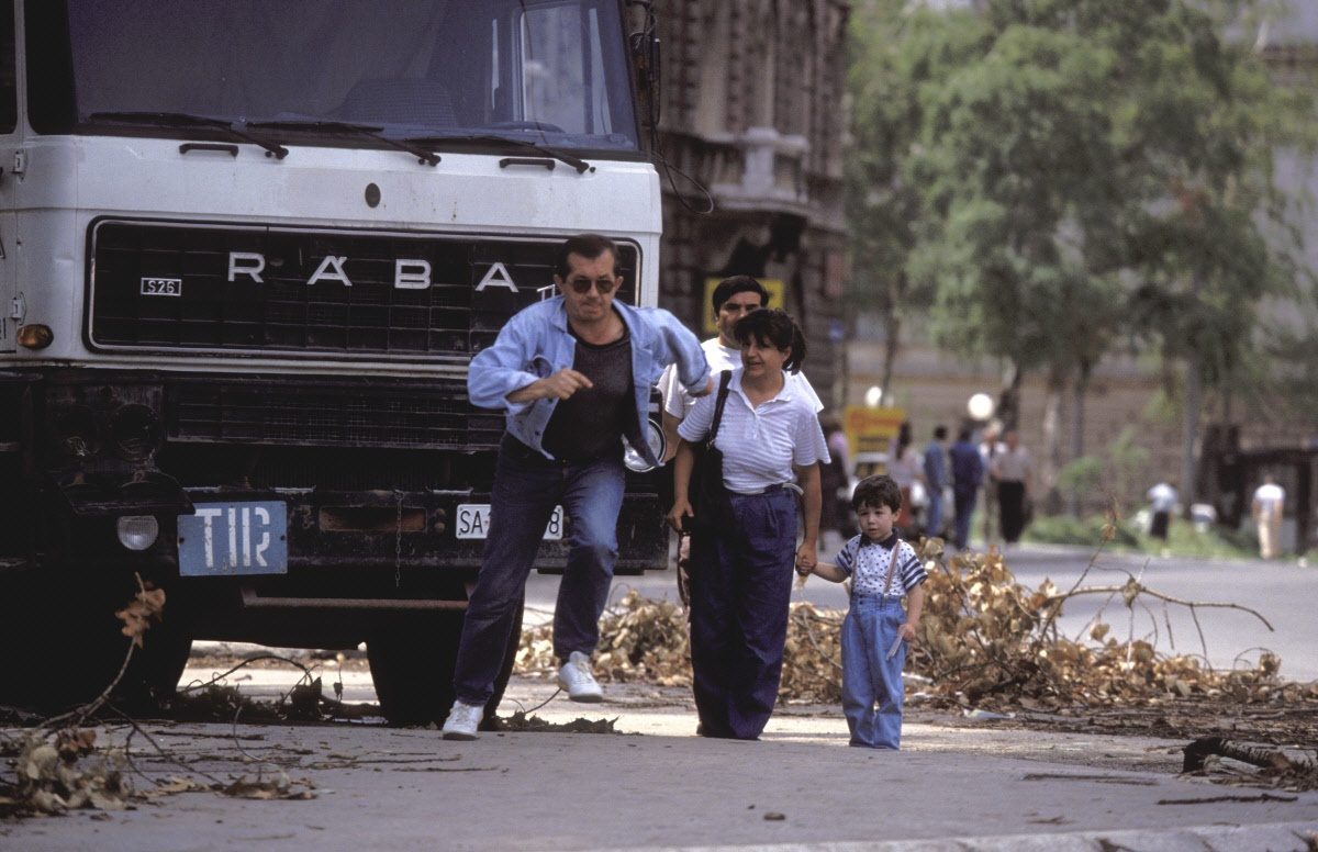 People run across an intersection, the infamous Sniper Alley, to avoid sniper fire during the siege of Sarajevo by Serb troops.