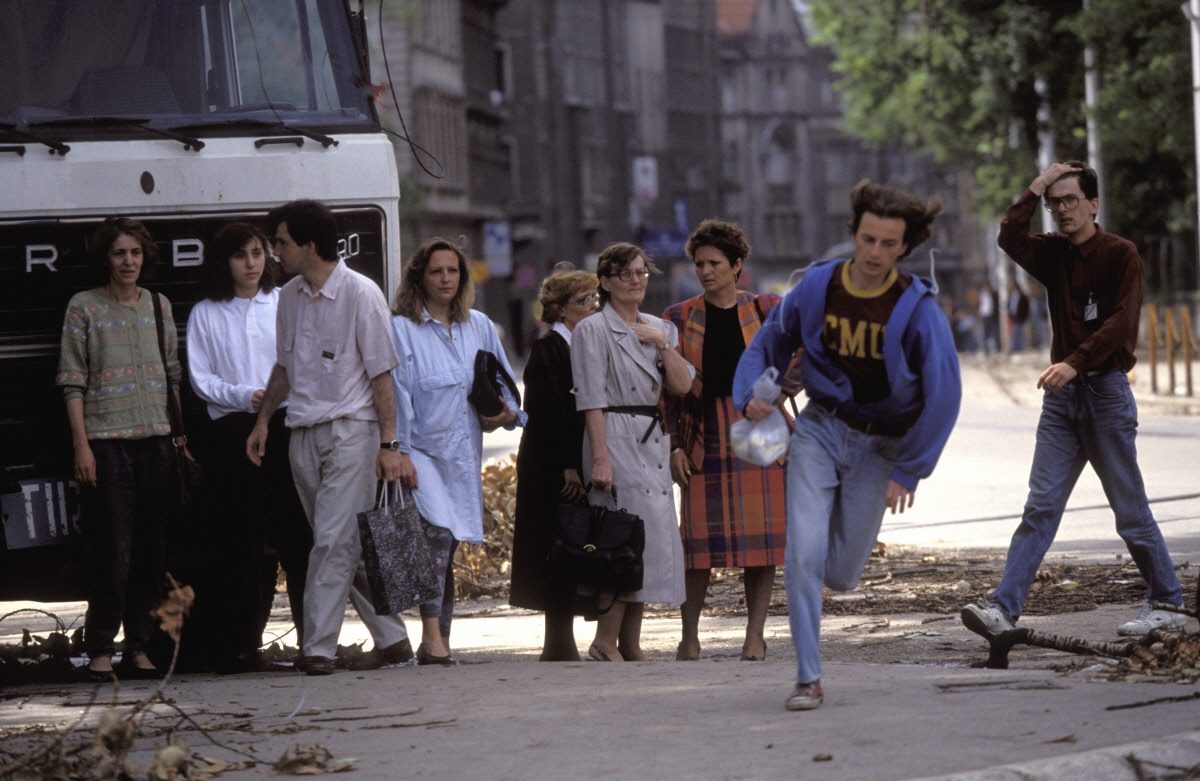 People run across an intersection, the infamous Sniper Alley, to avoid sniper fire during the siege of Sarajevo by Serb troops.