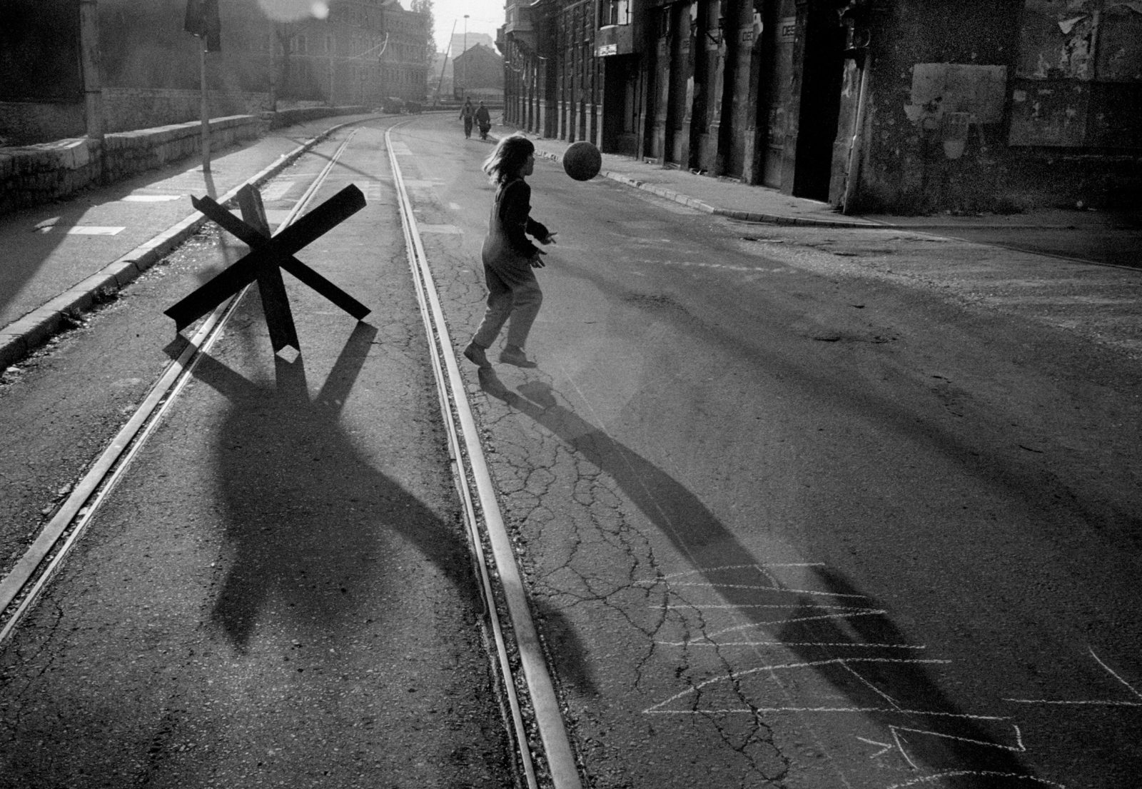 A young girl plays with a ball in the street alongside the River Miljacka in a ceasefire during the siege on Sarajevo by Serb troops.
