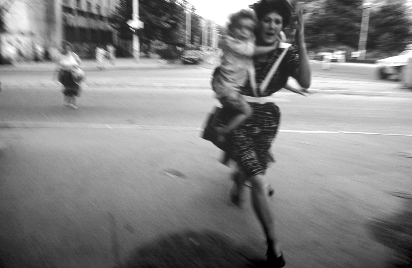 People run across an intersection, the infamous Sniper Alley, to avoid sniper fire during the siege of Sarajevo by Serb troops.