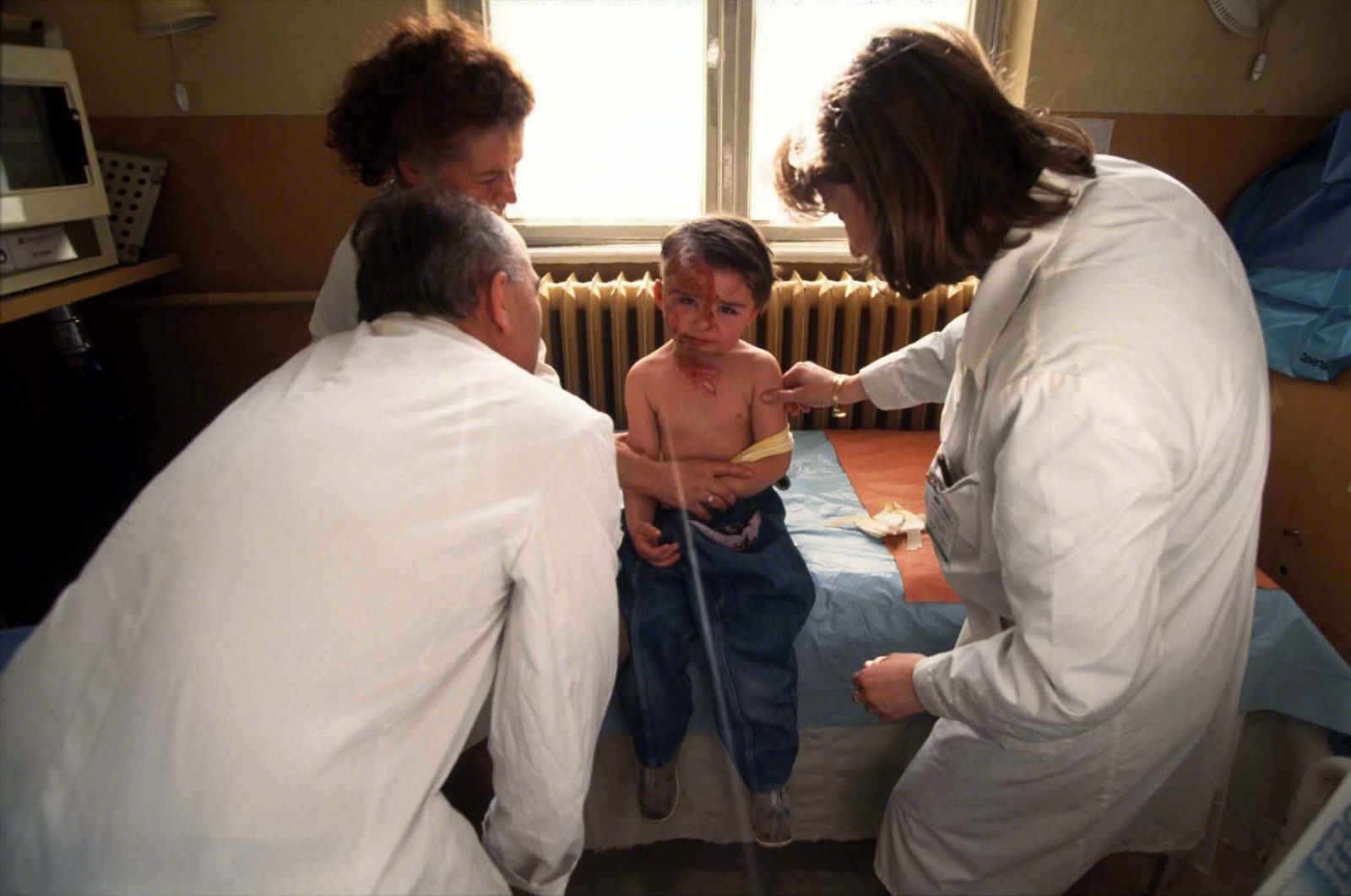 Sarajevo, 1994 Kosevo hospital medical staff giving treatment to boy (records lost, name unknown) with severe face injuries obtained during Sarajevo Siege fighting