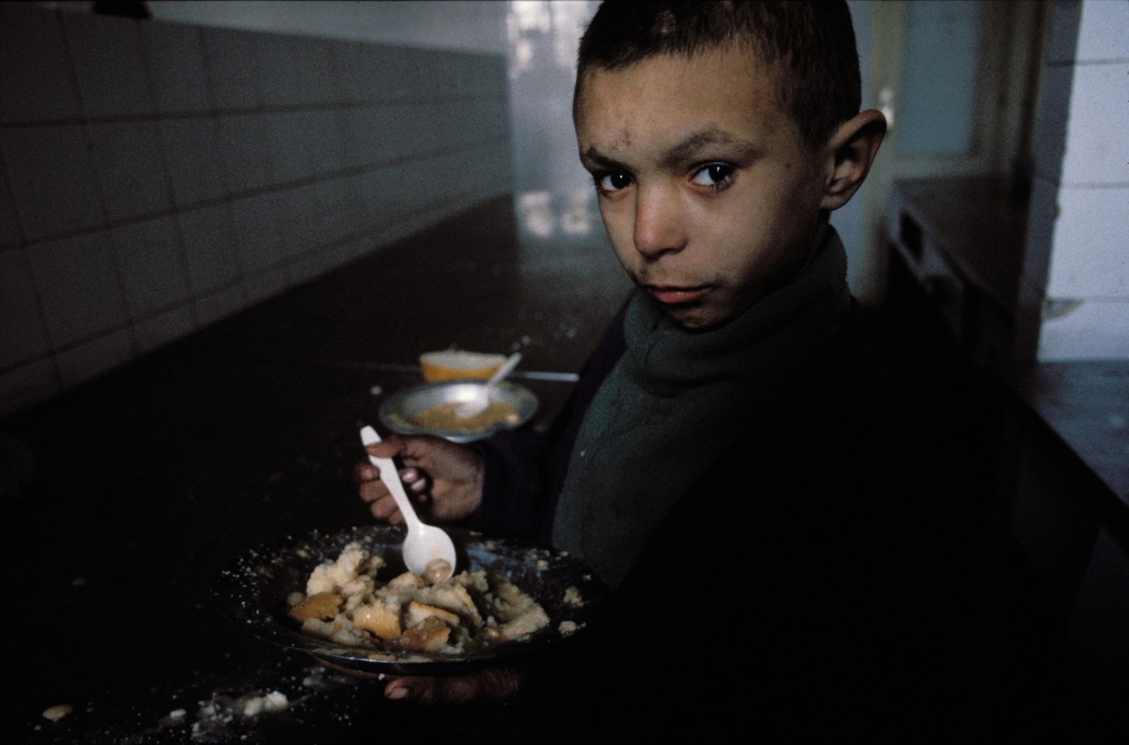 An orphan boy eats a meal of cold gruel and breadcrumbs at the unheated Sarajevo orphanage during the Bosnian Serb siege of Sarajevo, Bosnia and Herzegovina, February 1993. Almost 2,000 children, and over 10,000 people in total were killed in Sarajevo during the 3-1/2 year siege.