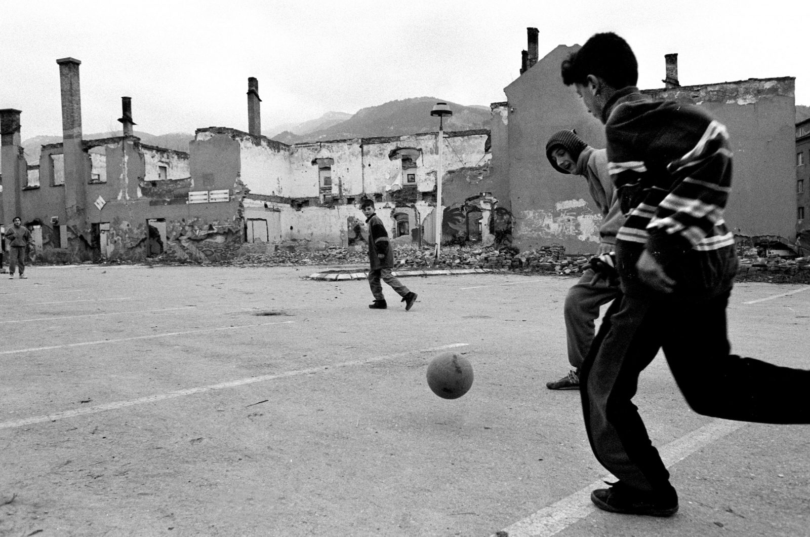 Boys play soccer in a downtown parking lot during the final days of the siege of the city, Sarajevo, Bosnia and Herzegovina, February 1996.