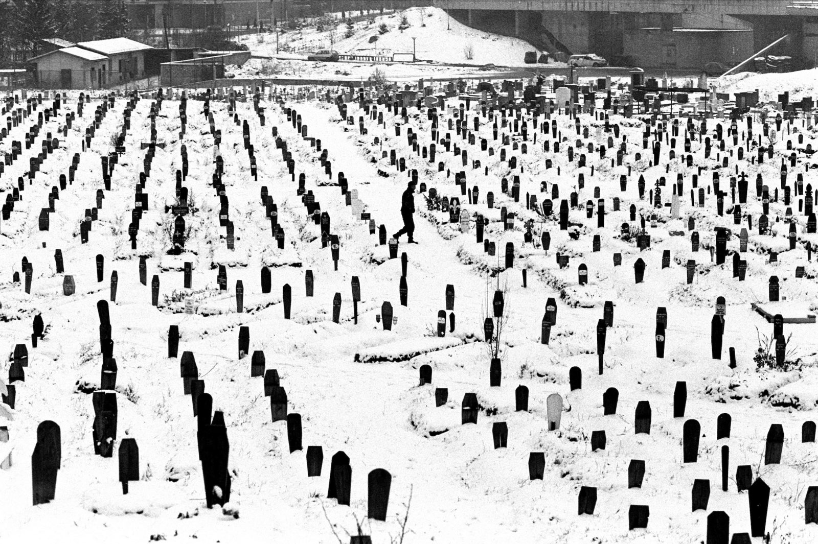 A Bosnian soldier walks through the Kosevo soccer field that was turned into a cemetery, during the final days of the siege of the city, Sarajevo, Bosnia and Herzegovina, February 1996.