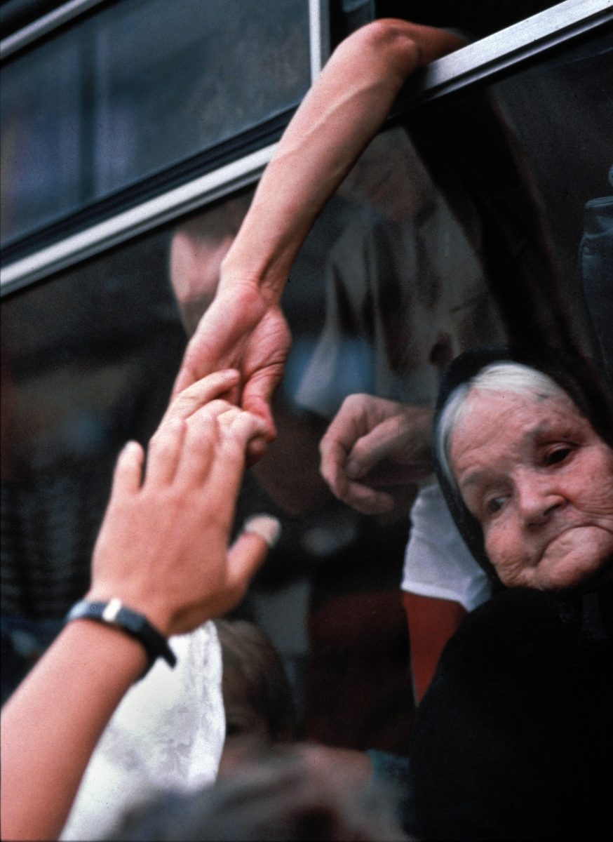 Bosnian refugees, some from Sarajevo, cling to each other as their Red Cross bus departs for sanctuary in western Europe, Zagreb, Croatia,1992.