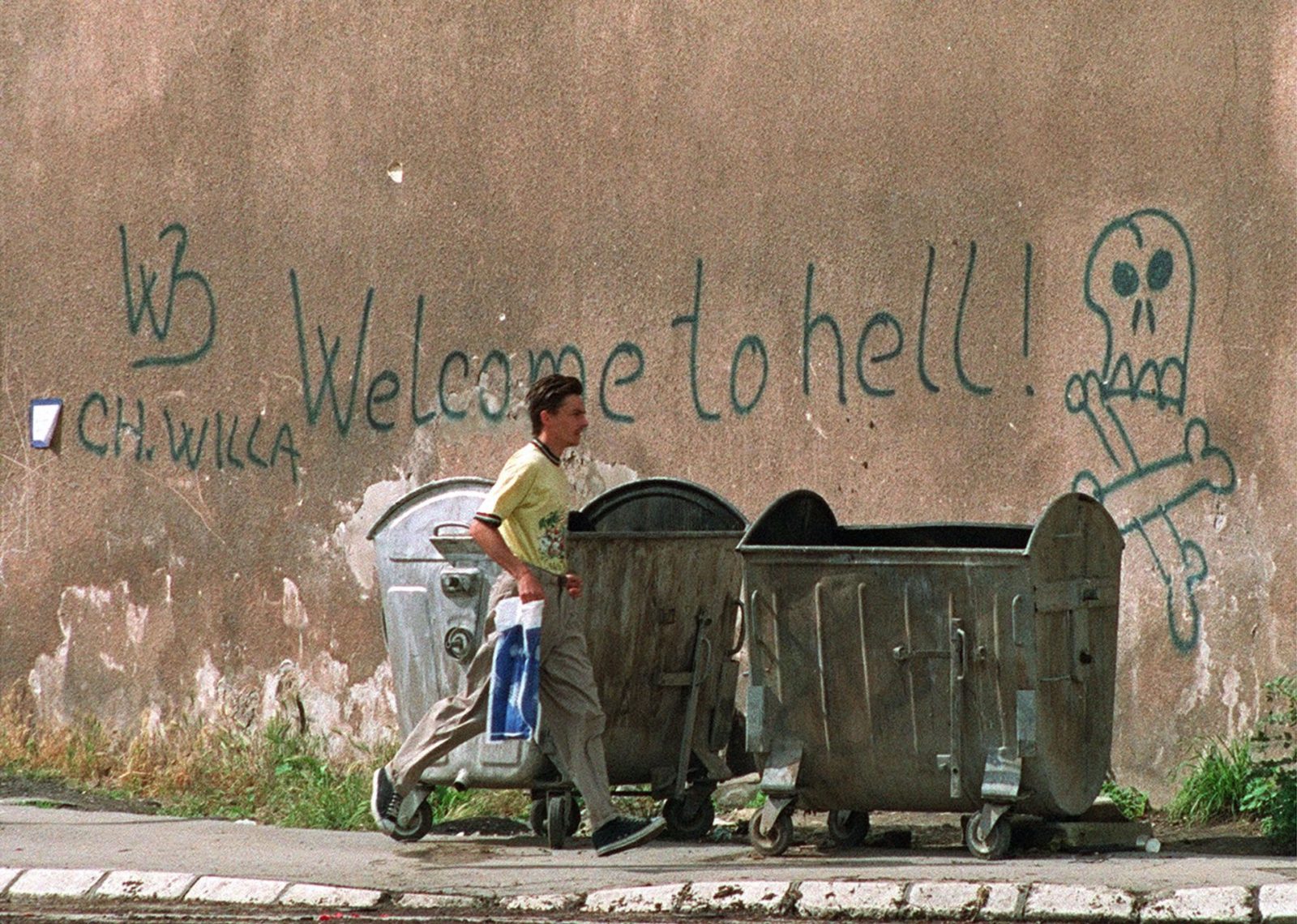 A man walks past graffiti in the besieged capital of Sarajevo, Bosnia-Herzegovina on Friday, June 12, 1992. The city's streets became virtually deserted every afternoon as Serb shelling from surrounding hills intensified.
