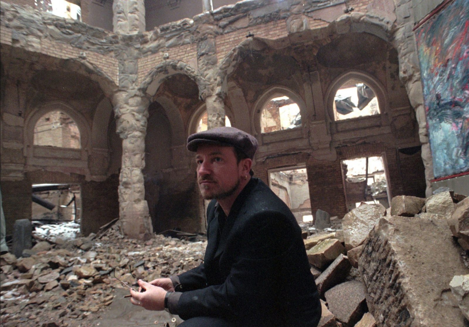 Bono leader of the group U2, contemplates the destruction in the war-torn Sarajevo library during a brief visit Sunday, December 31, 1995. Bono is taking advanatge of the Dayton peace agreement to visit the city. Bono, a friend of the youthful Foreign Minister Muhamed Sacirbey, spent much of his first night in Sarajevo in a popular downtown restaurant with a motley collection of politicians, reporters and Sarajevans. The singer said he was on a two-day private visit with his wife, Ali, to Sarajevo. ``I'm here for a party. I heard New Year's Eve is a great party .... in this city,'' he told Associated Press Television.