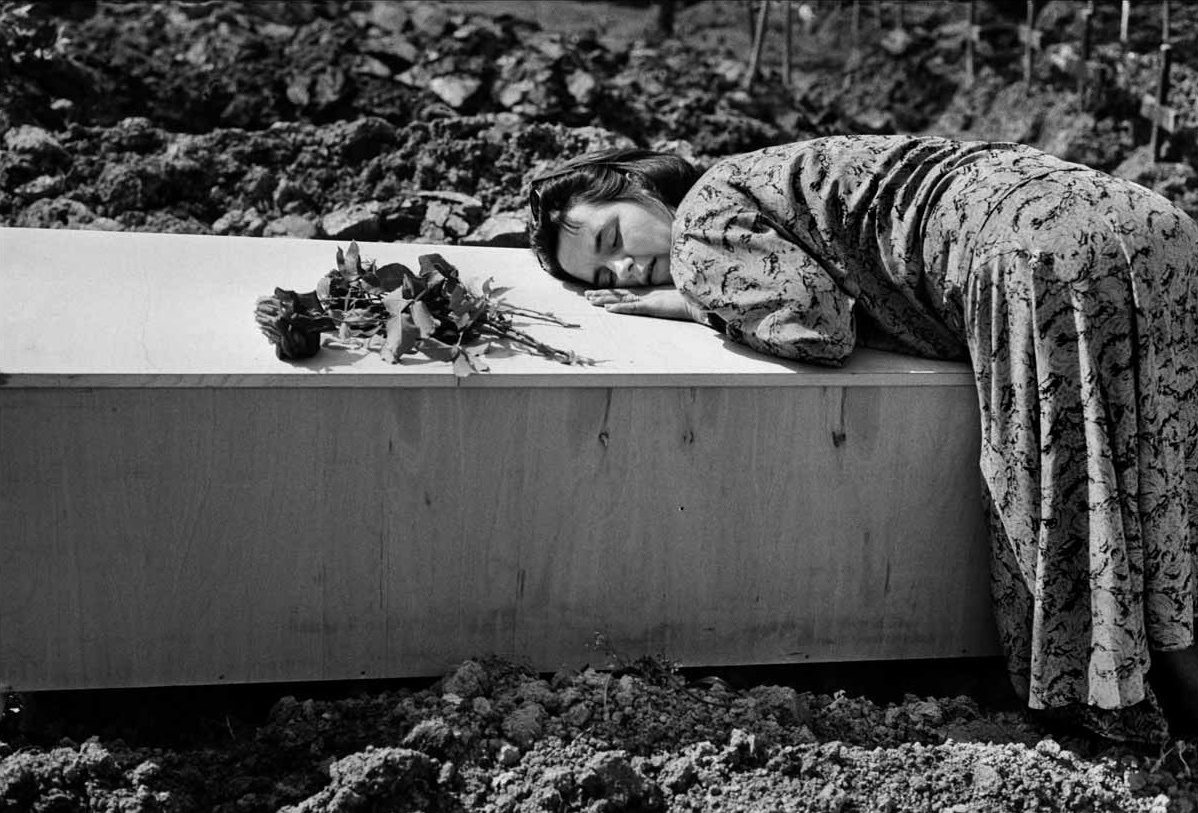 Sarajevo, 1992. A young widow grieves over the coffin of her husband during his burial in the Lion Cemetery, Sarajevo. (Photo By Tom Stoddart/Getty Images)